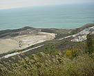 Trucks and levelled ground next to sea